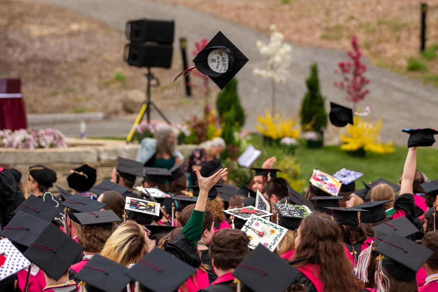 Crowd of graduated UMF students throwing their caps in the air.