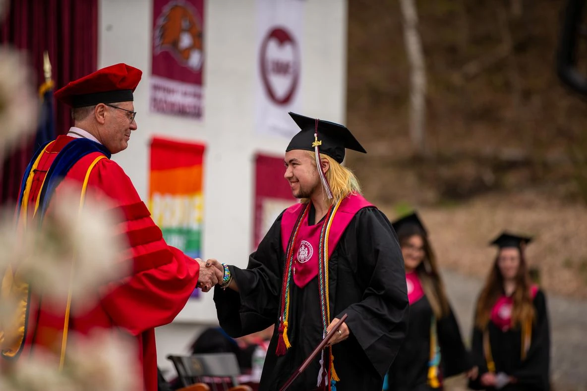 Johnson Scholar student shakes hand with President of UMF at graduation