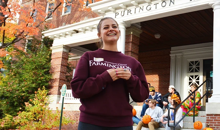 A Female Student smiling for a photo outside of Purington Hall