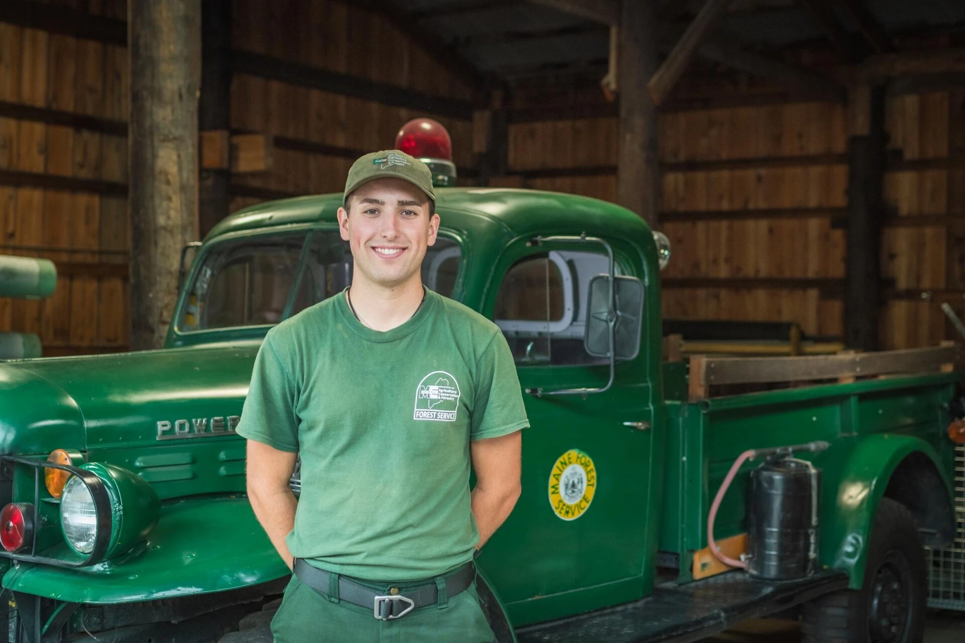 Outdoor Recreation and Business Administration students stands smiling in front of green truck.
