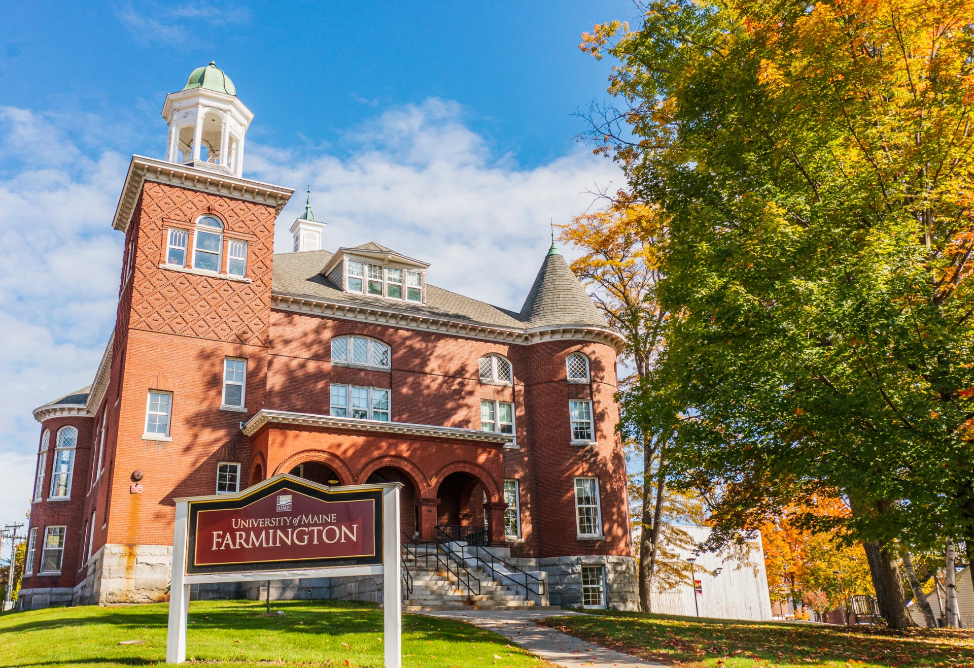 University of Maine Farmington campus building on a sunny day with some trees.