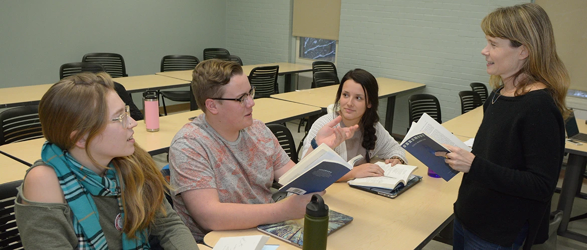 English students and professor discuss novel in classroom.