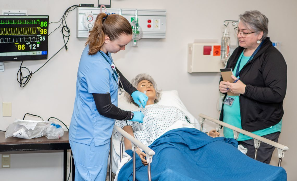 UMF nursing program student and professor working together in the classroom.