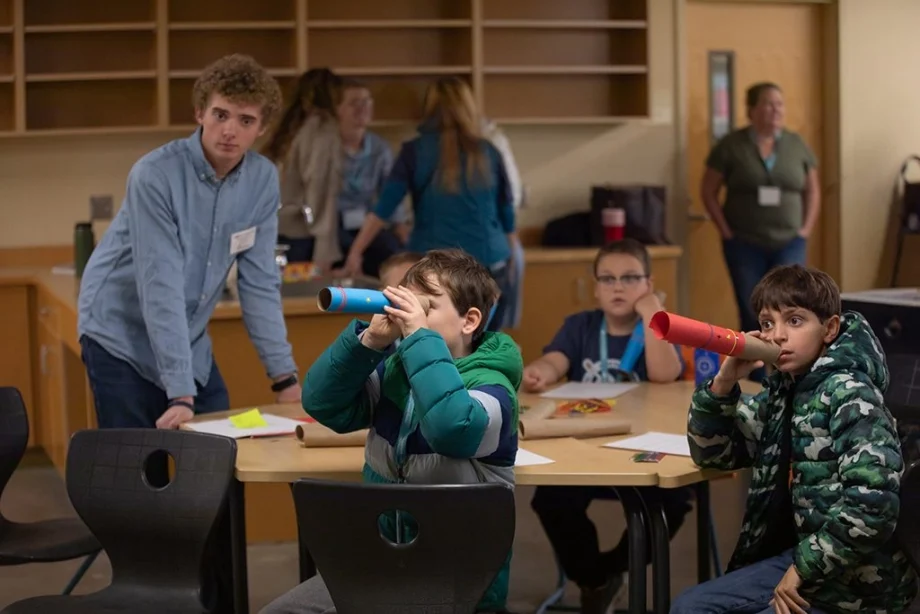 Devyn De Leonardis, UMF Elementary Education major, helping students with telescope project.