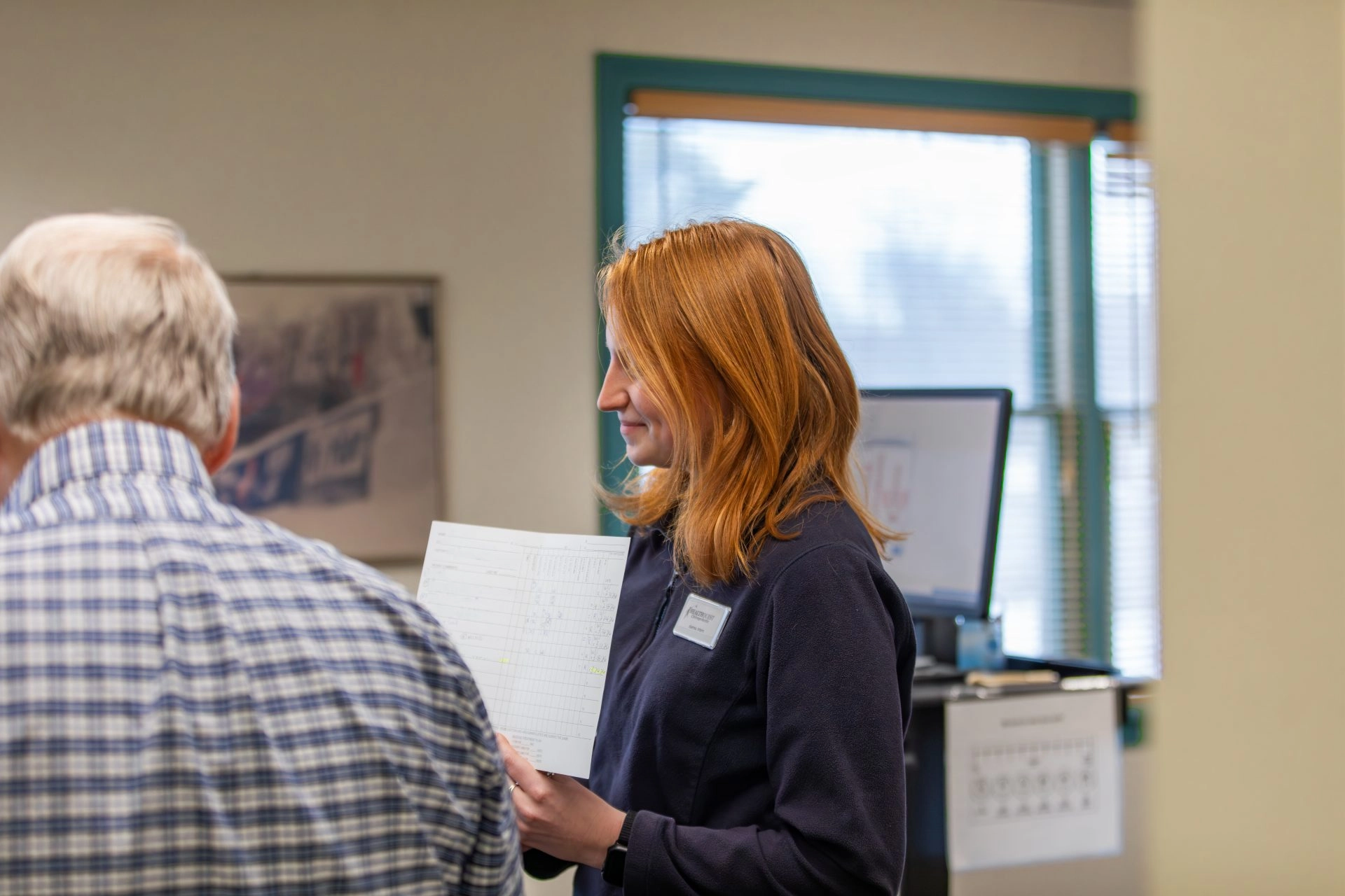 UMF Chiropractic Student Intern holds paper up for doctor to read