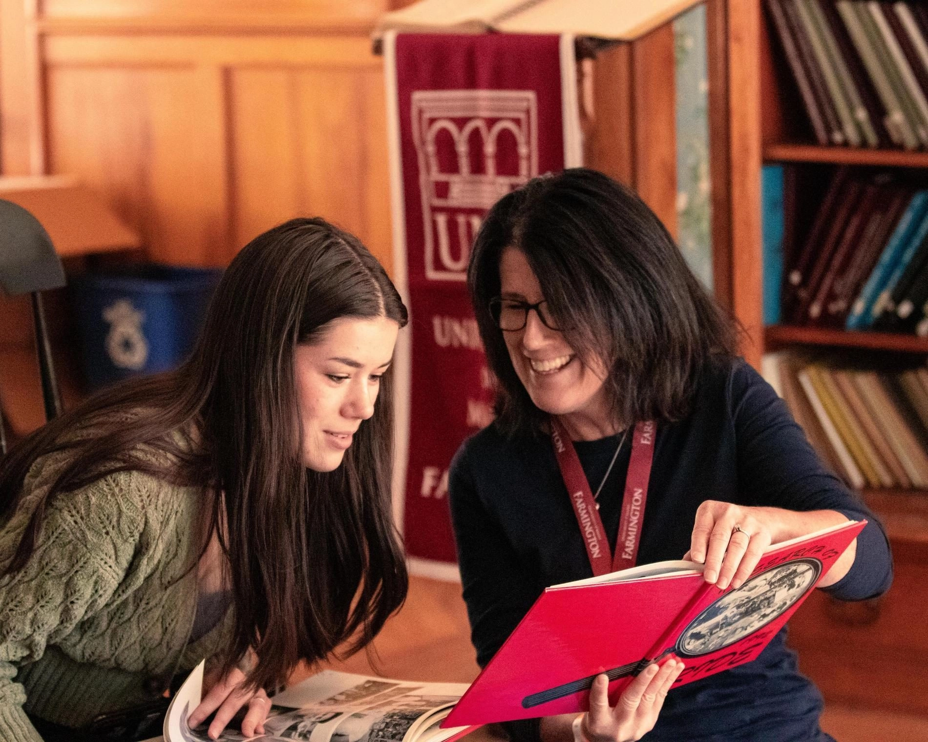 Alumni showing yearbook to student