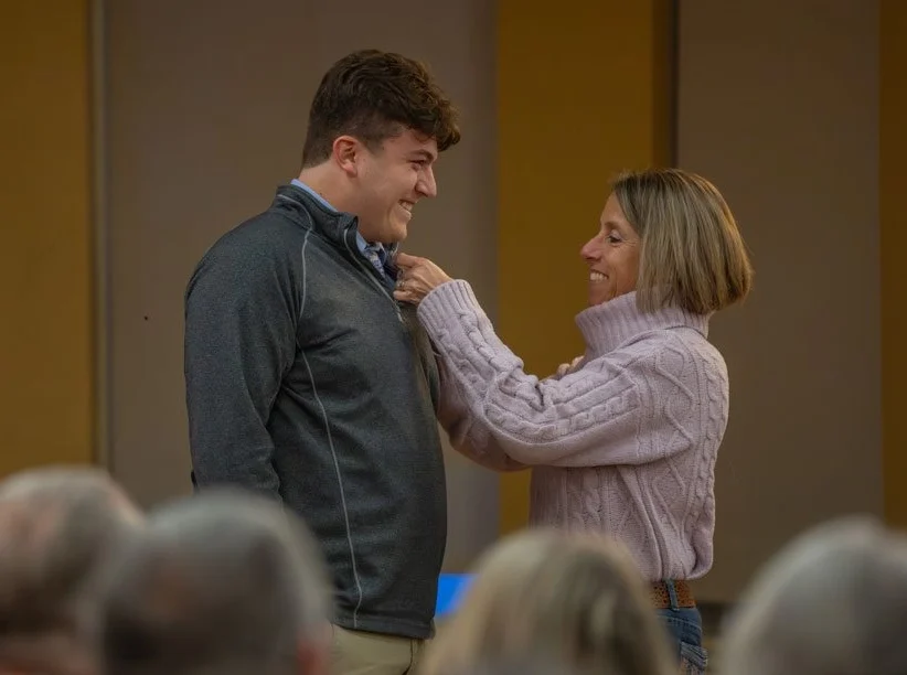 Person pinning special education ceremony on a graduate