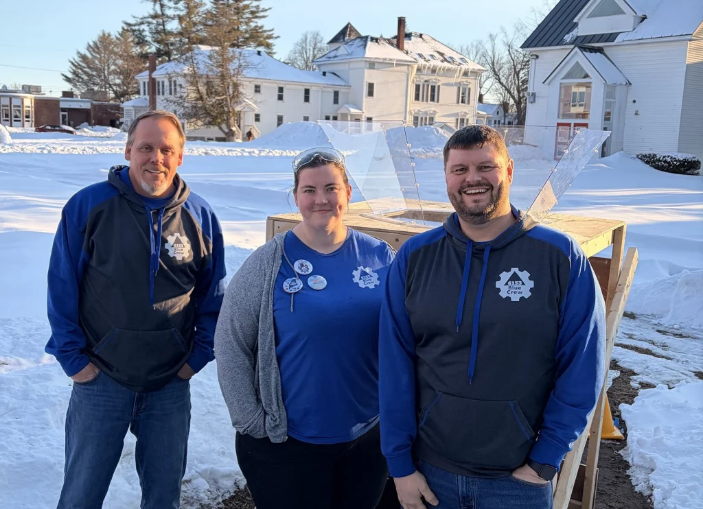 Blue Crew Mentors and UMF alumni (Left to right) Rob Taylor '89, Katie Joseph '17 and Jeff Bailey '98 work with high school robotics team.