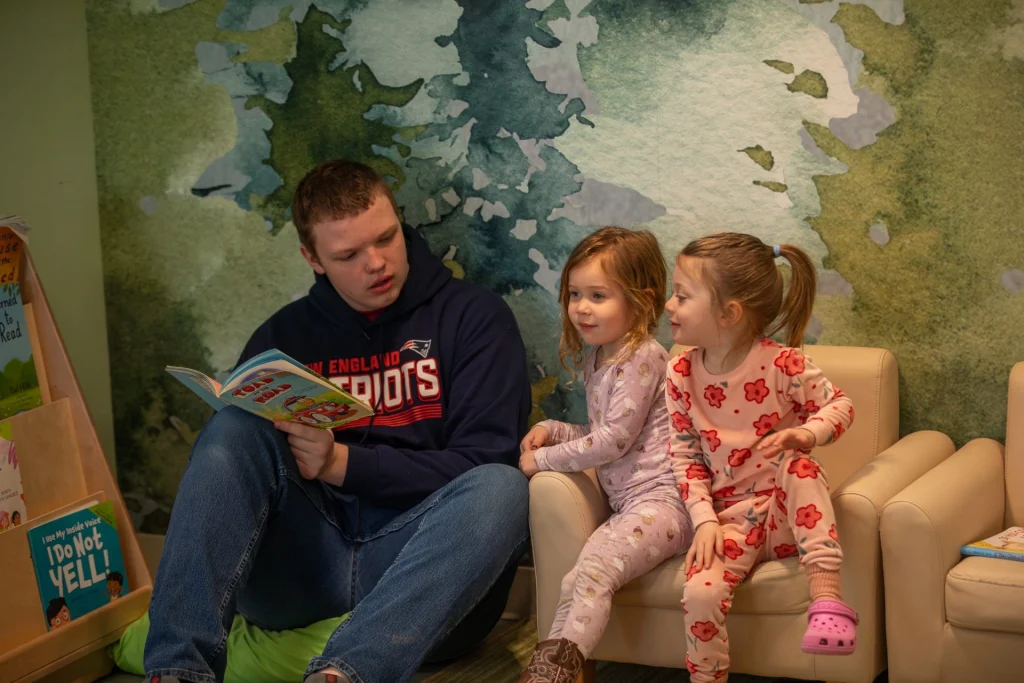 Mt. Blue Middle School student reads to tow preschool girls.