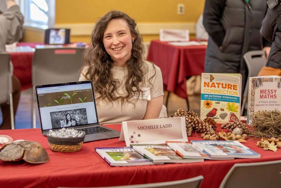 Student smiling sitting at table presentation on nature education