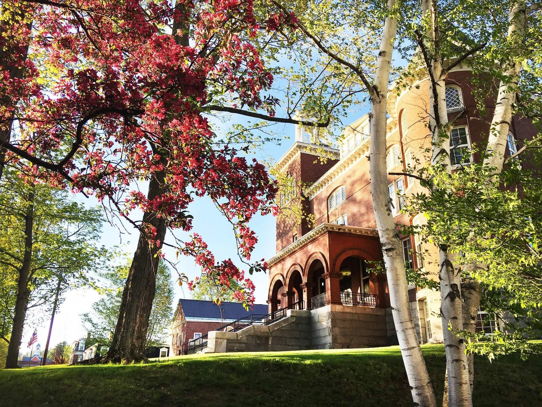 Exterior image of Merrill Hall with spring flowers and trees