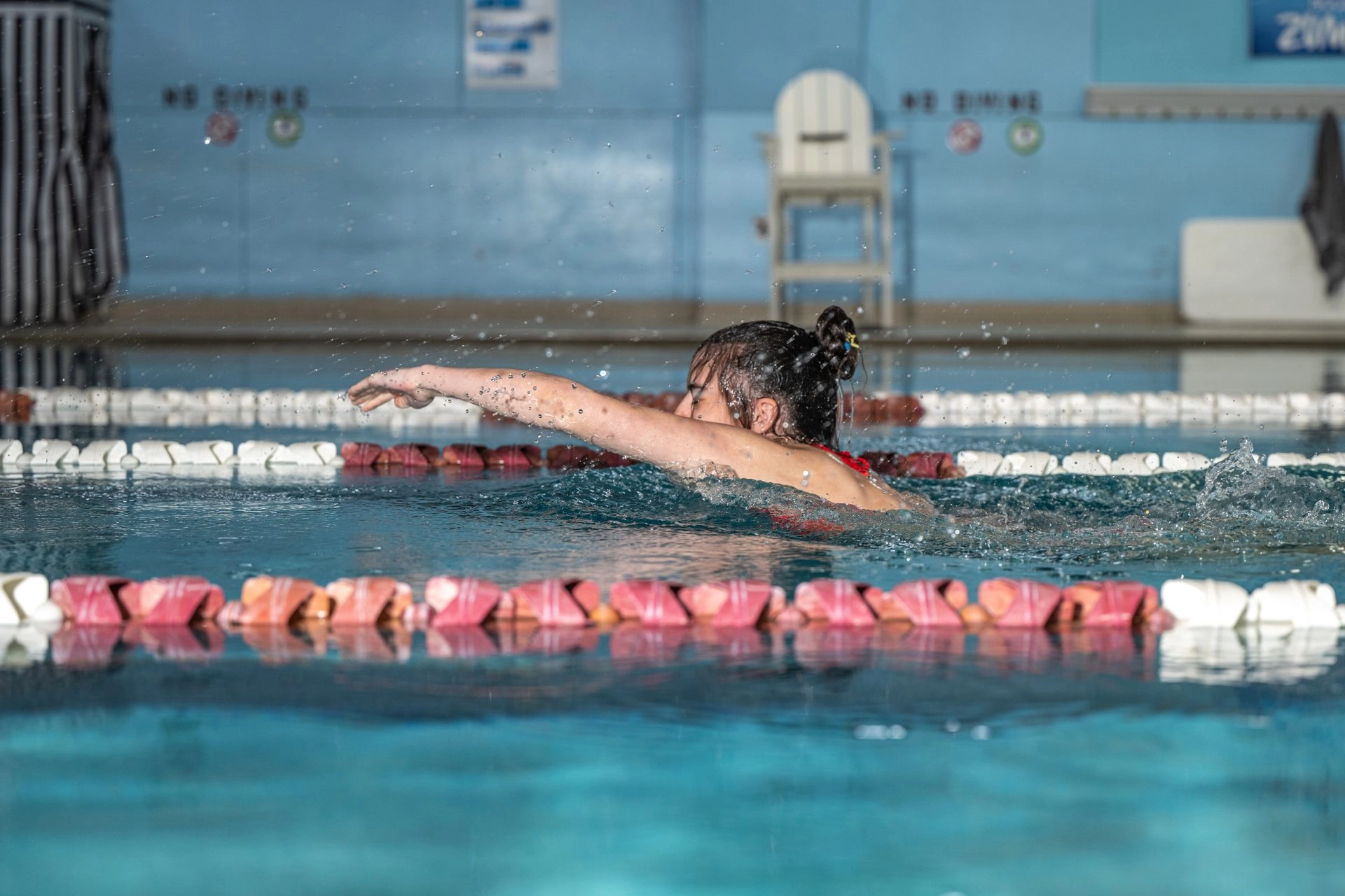female student swimming in the FRC pool with water splashing