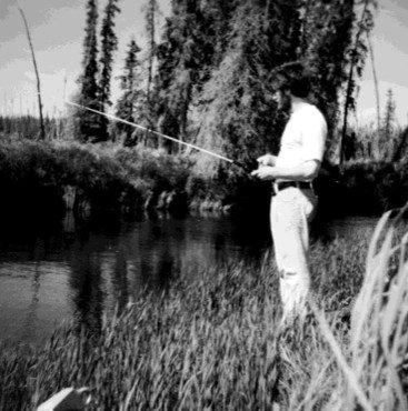 Image of Michael D. Wilson fishing at a stream