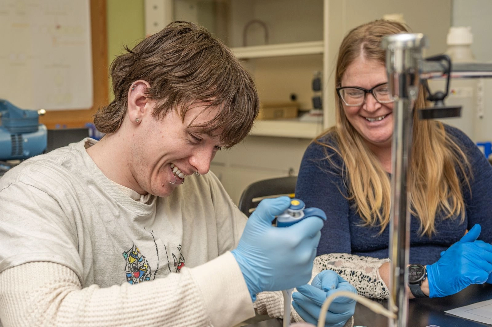 Student and professor performing experiment in a lab indoors