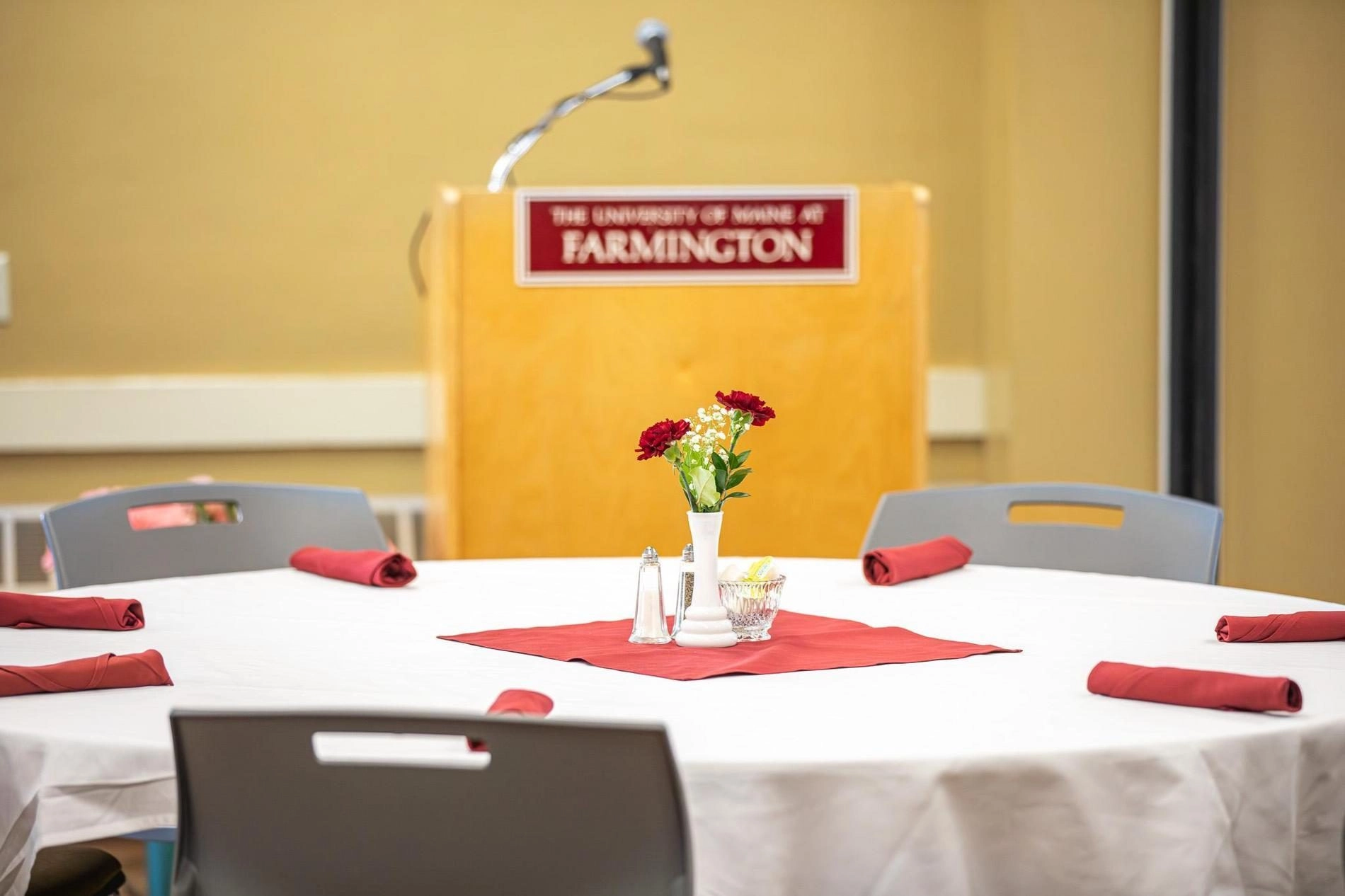 Table setting with flowers in the middle in front of a podium