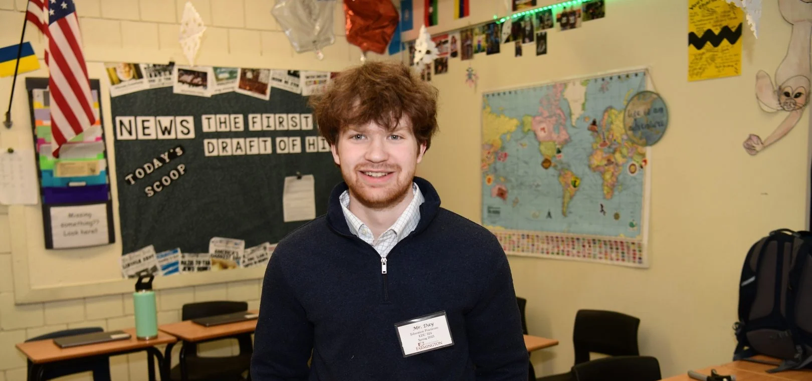 Teacher in front of bulletin boards in classroom