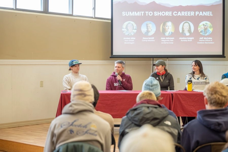 Panel of guest speakers in front of a crowd at the Summit to Shore Career Festival