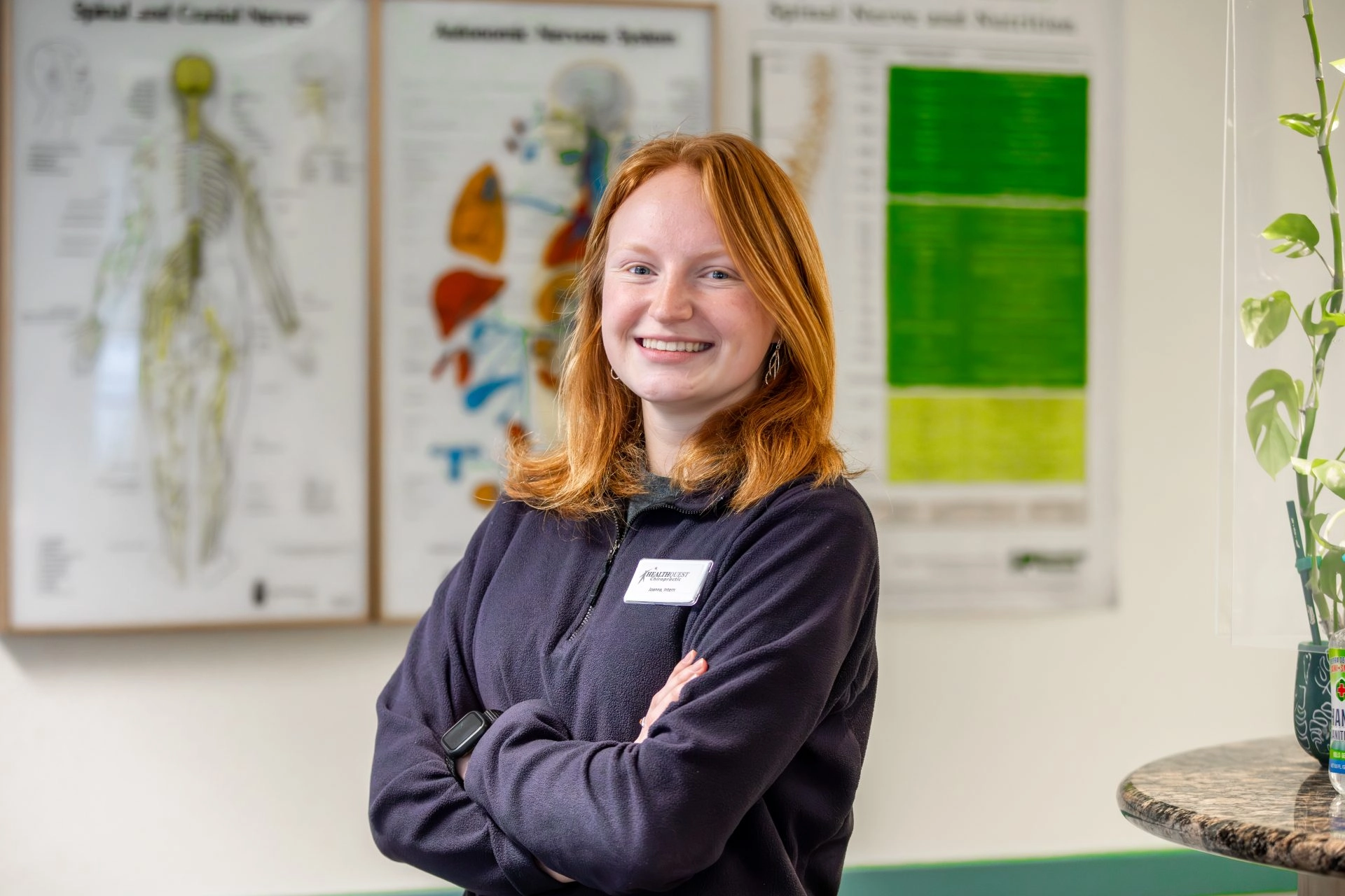 Student smiling in front of body diagrams on the wall