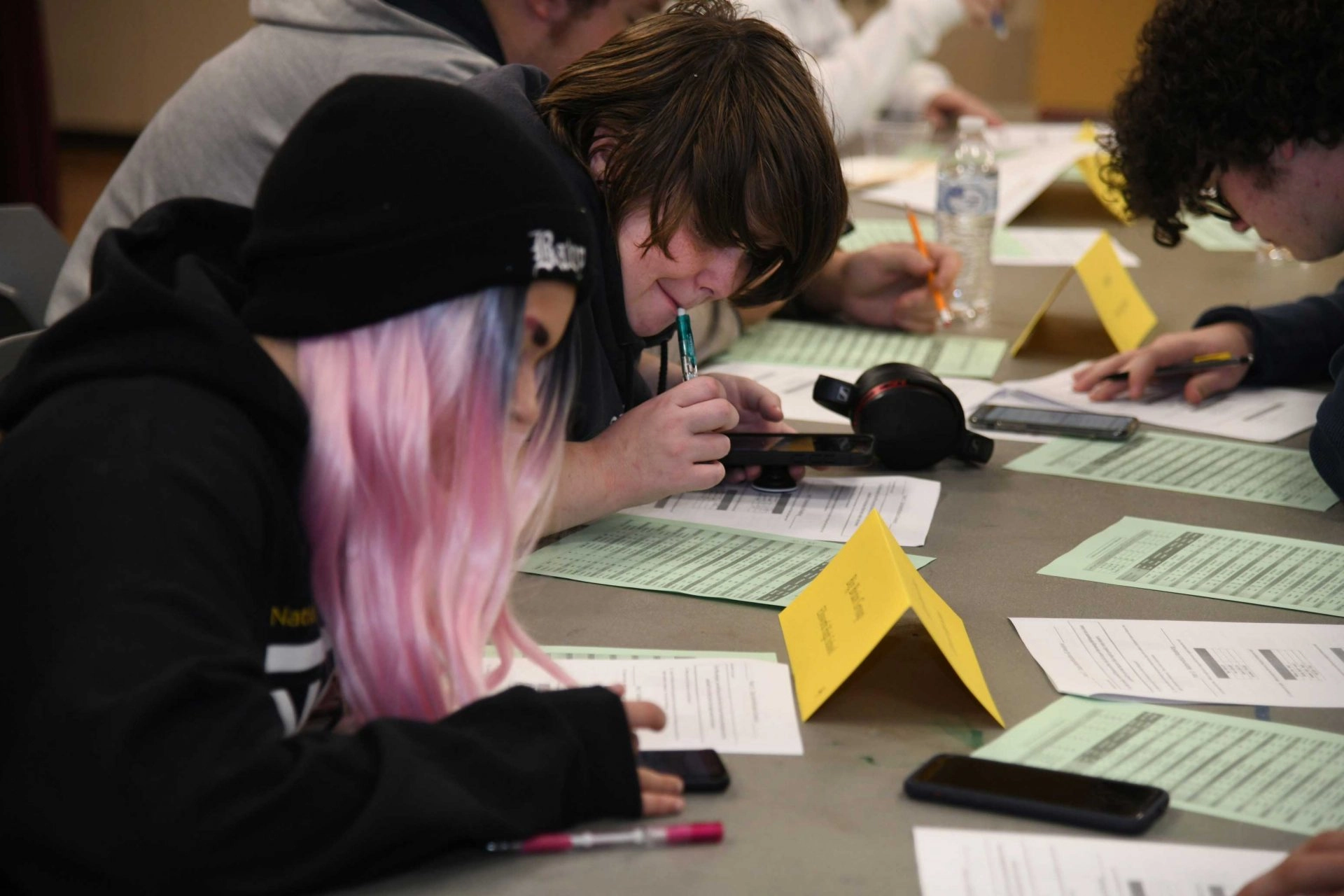 Students working math problems on sheets on a table