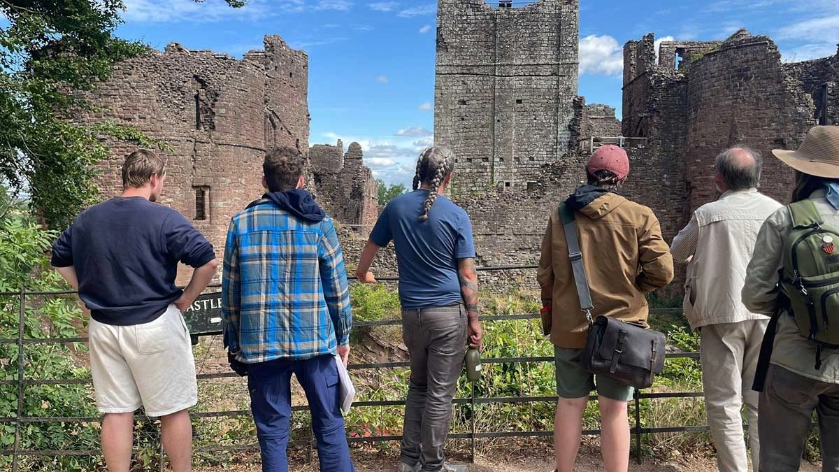 Anthropology students standing in front of a castle.