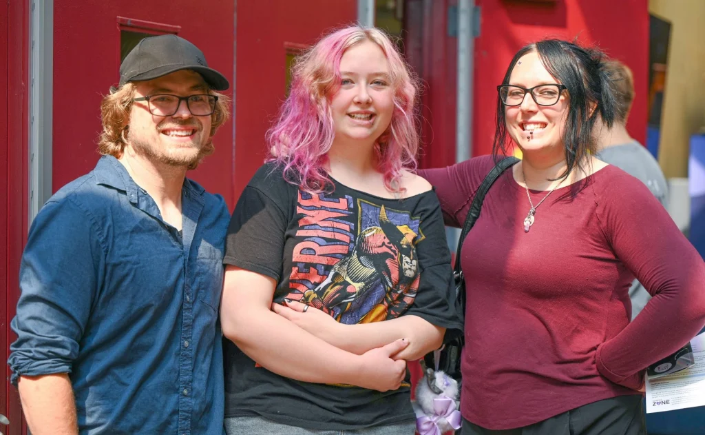 Happy parents pose with their daughter on move-in day at UMF