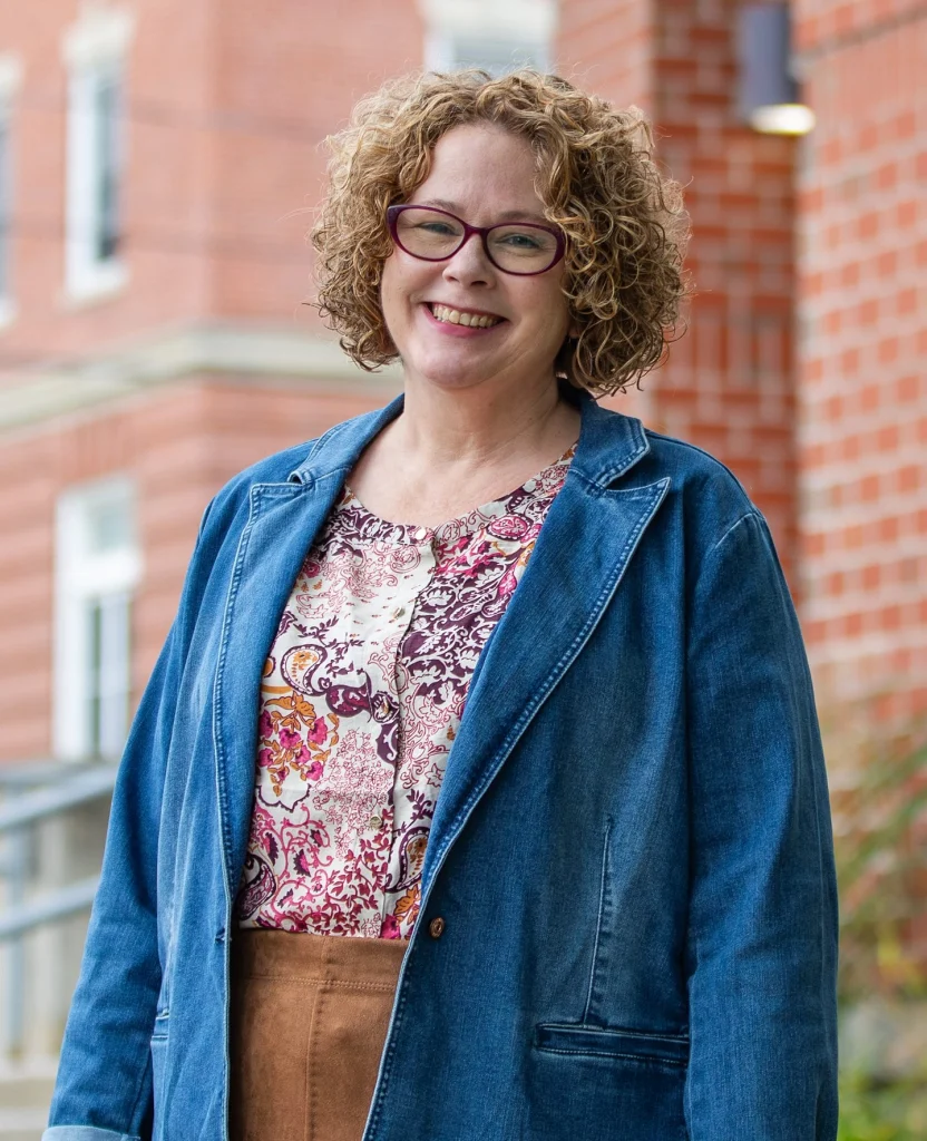 Smiling woman with glasses in floral shirt