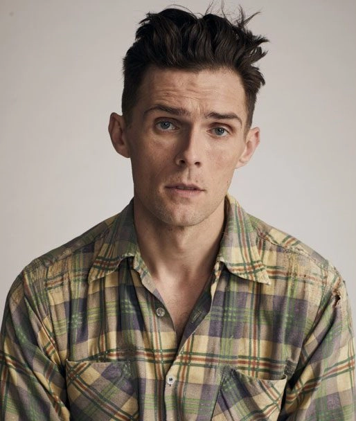Young man with plaid shirt and expressive look on his face