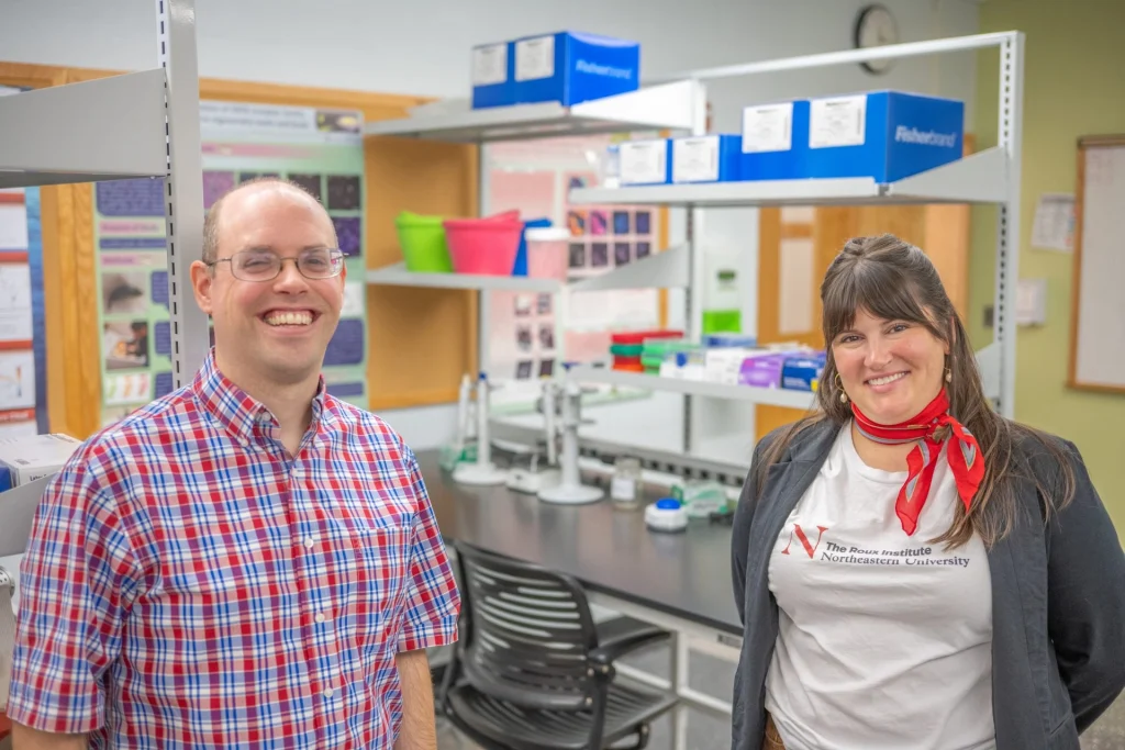 Smiling man and woman standing in a biology lab on the Farmington campus