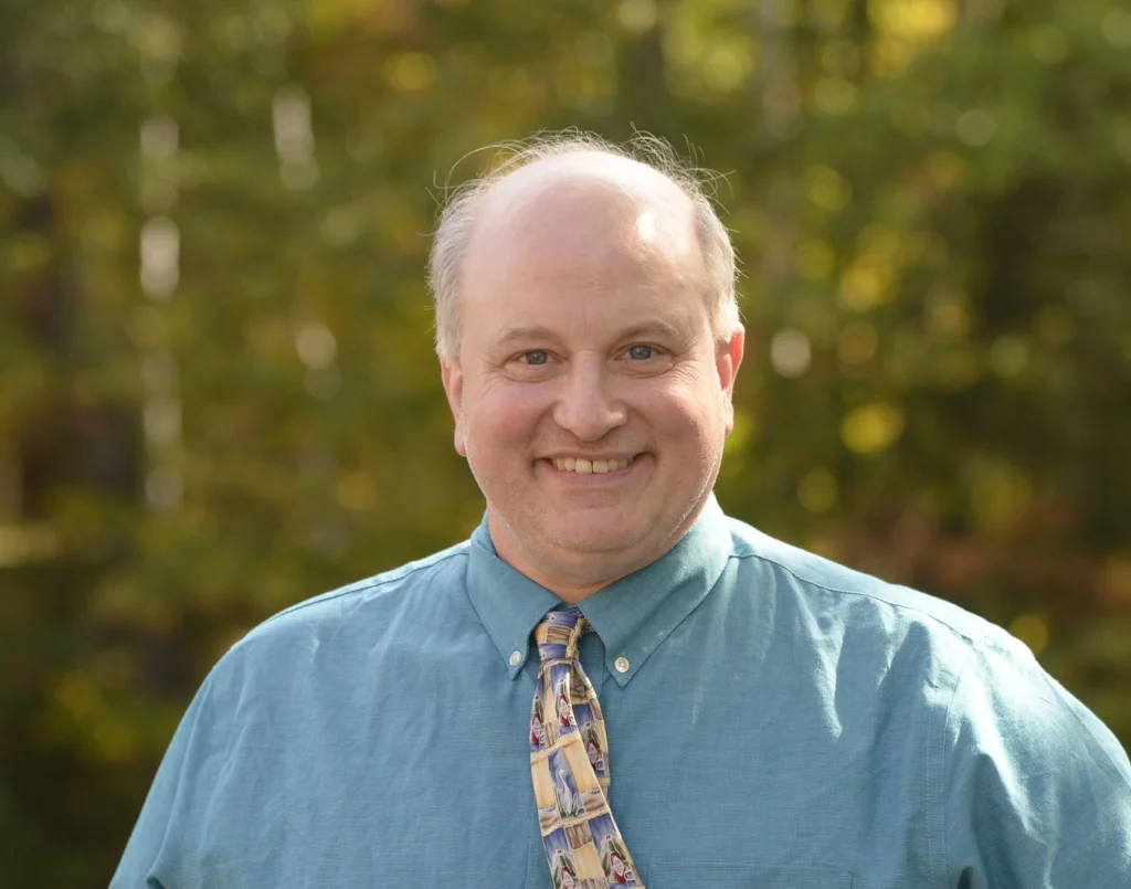 Smiling man in blue shirt and tie
